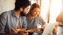 Couple souriant devant un ordinateur