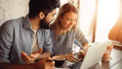 Couple souriant devant un ordinateur