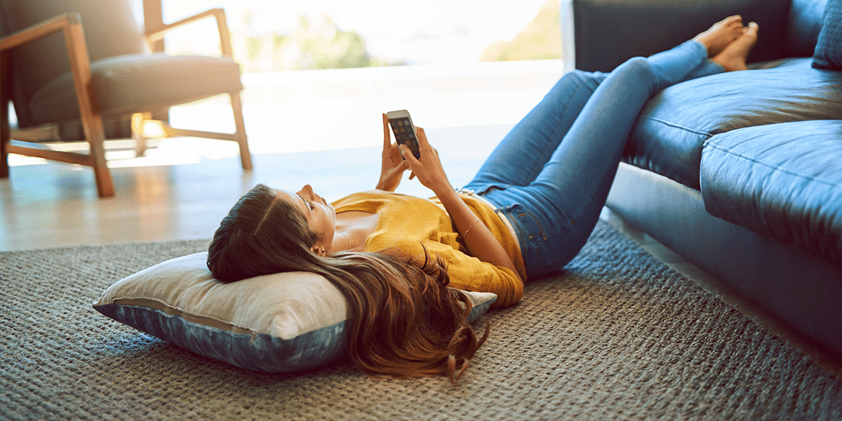 femme allongée par terre avec téléphone